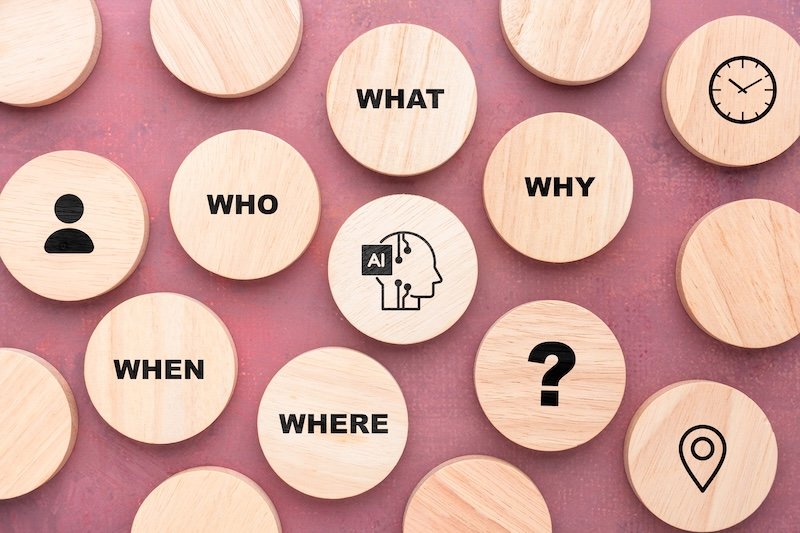 Wooden blocks illustrating AI surrounded by many kinds of questions, representing contextual understanding, reasoning, knowledge retrieval, intelligent search, and AI assistants