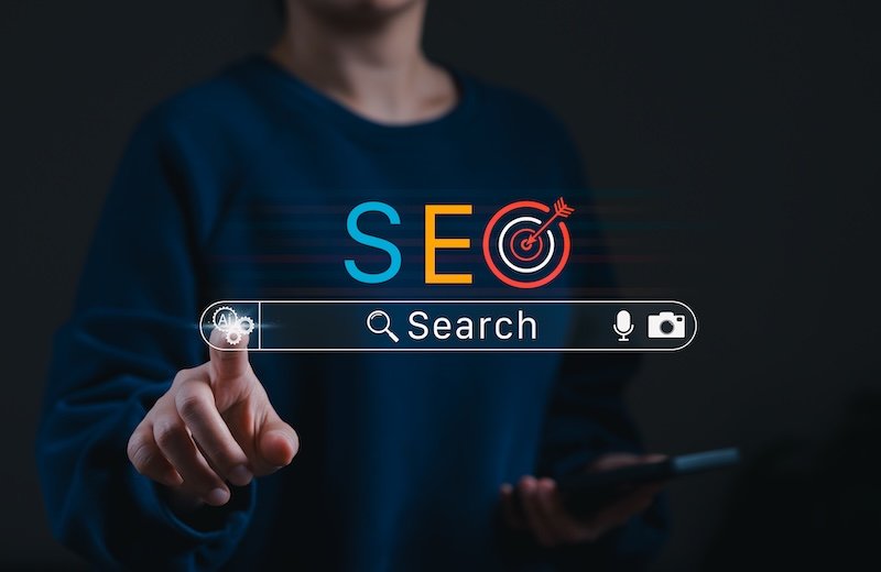 SEO Search engine optimization concept. Person touching digital search bar with AI icon, mobile device, and target symbol representing online marketing strategy, keyword research, analytics and growth
