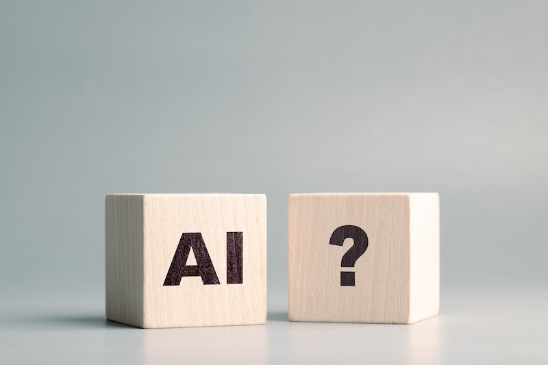 AI text and Question mark symbol on the wooden cubes, confusion about AI, how to use, and ask, questions about AI technology