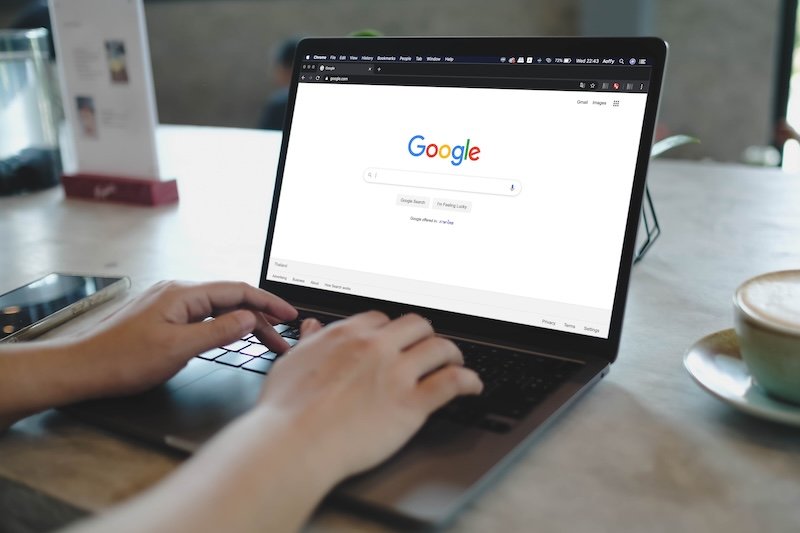 Bangkok, Thailand. September 22, 2025; A person using the Google search engine on a laptop to find information on the internet, with a cup of coffee at their desk.
