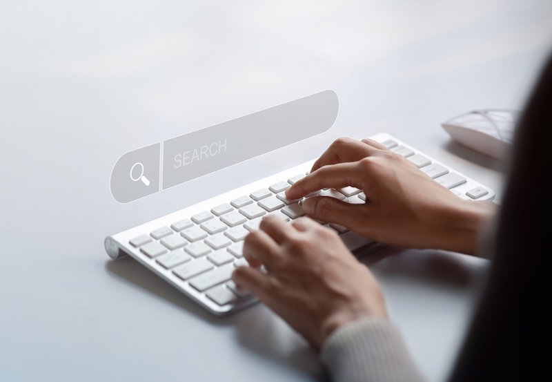 The user is typing a keyboard with a hologram search box. Searching information on the Internet, cloud information online can search information from all over the world. Search engine.